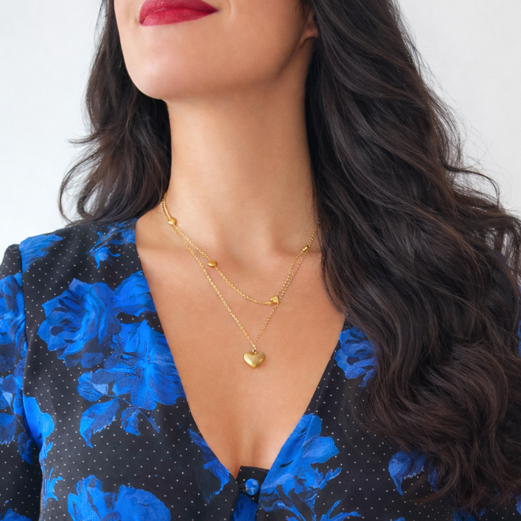 Woman wearing a blue floral dress with a gold heart necklace